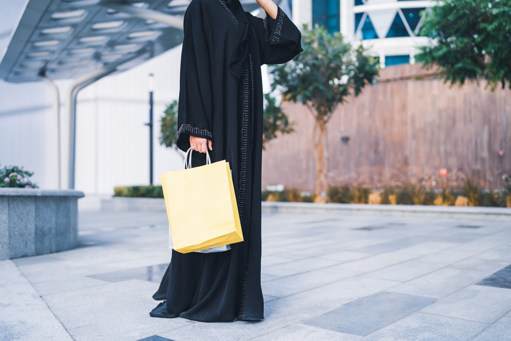 Arabic woman wearing abaya and doing shopping.
