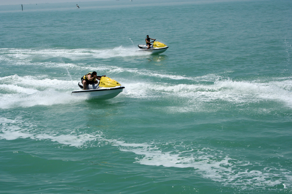 2 people riding 2 jet skis in Kuwait.