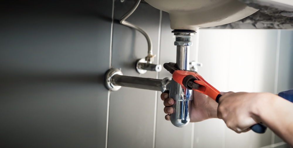 a plumber hands on a pipe.