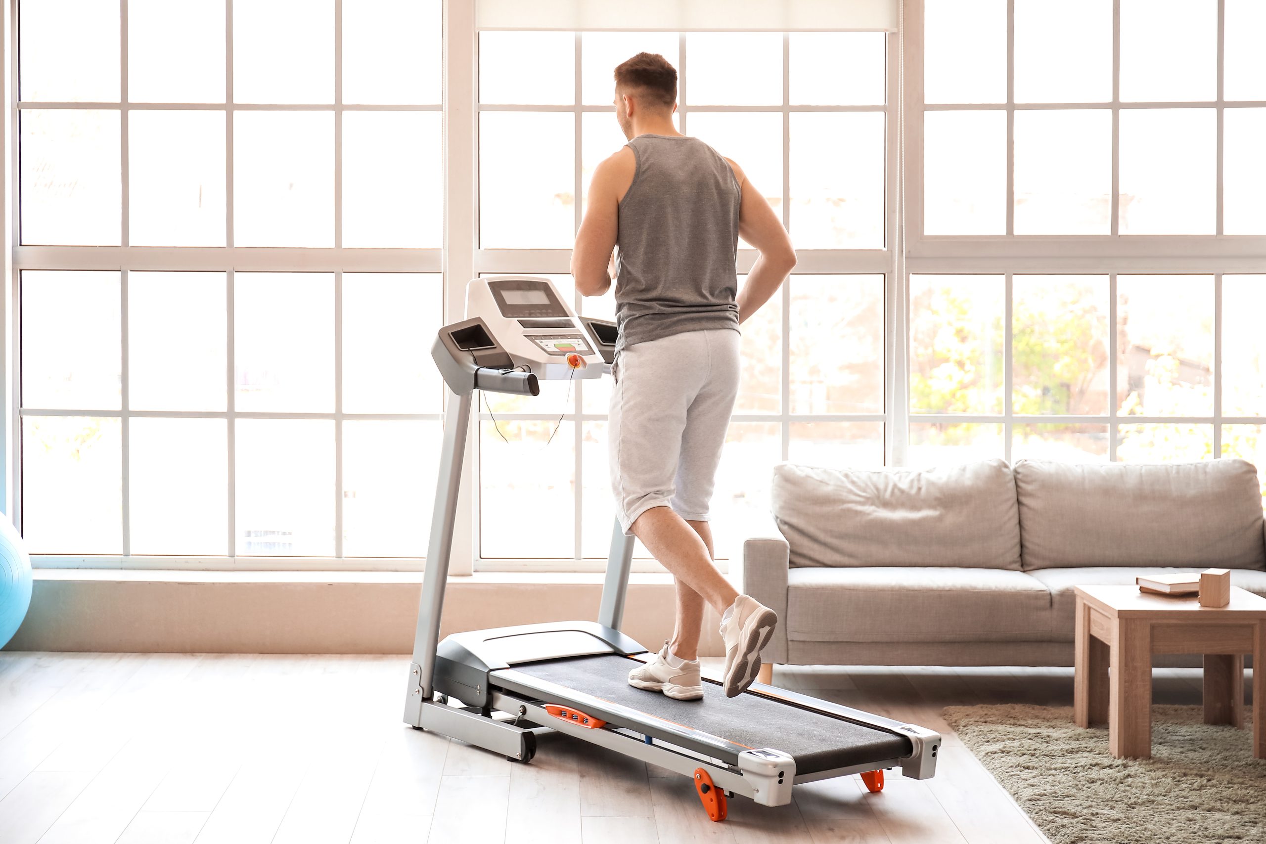 A man running on a treadmill at home