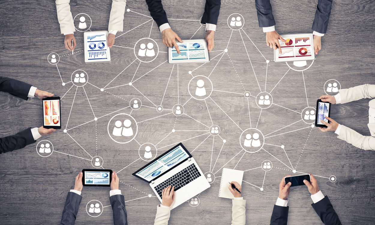 Group of users holding devices and meeting online.