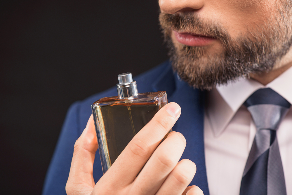 رجل يشم رائحة العطر.