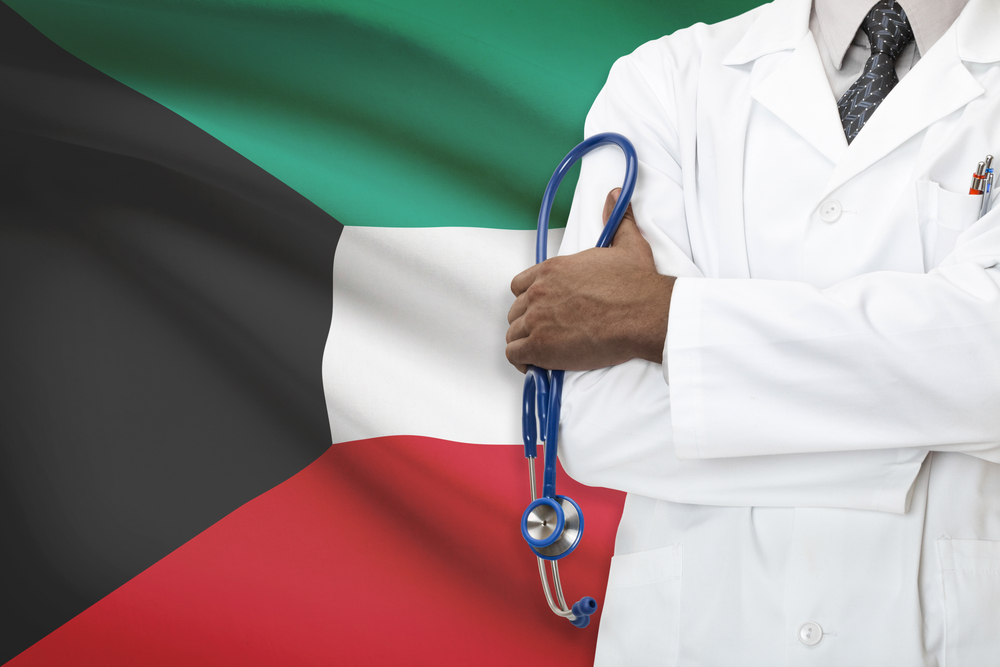 طبيب وفي الخلفية علم الكويت.